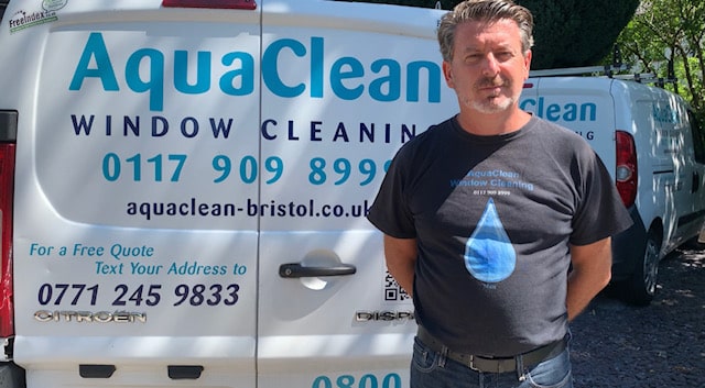 AquaClean owner beside the company vans
