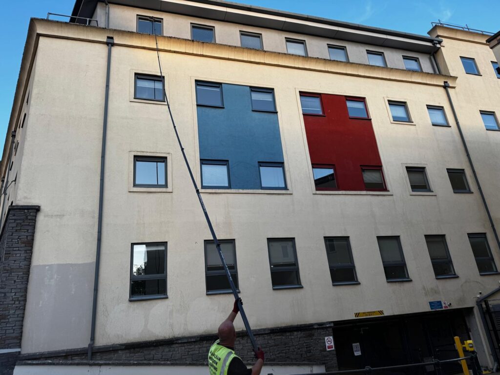 AquaClean operative using an extended pole to clean upper-floor windows